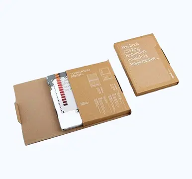 Two cardboard mailer boxes - one open showing interior with design guide, one closed
