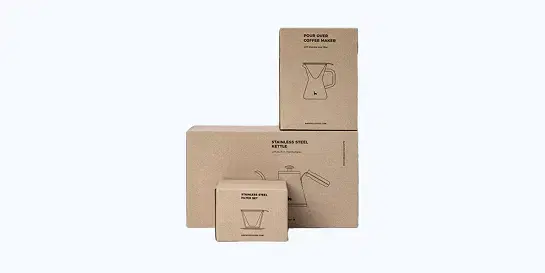 Stack of three minimalist brown cardboard product boxes for coffee-making items labeled 'POUR OVER COFFEE MAKER', 'STAINLESS STEEL KETTLE', and 'STAINLESS STEEL FILTER SET' with line art illustrations
